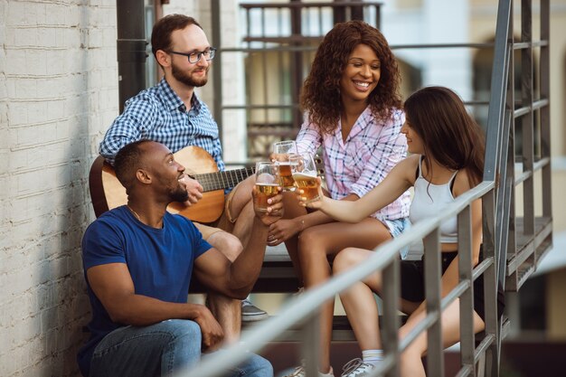 夏の日にビールパーティーをしている幸せな友達のグループ。