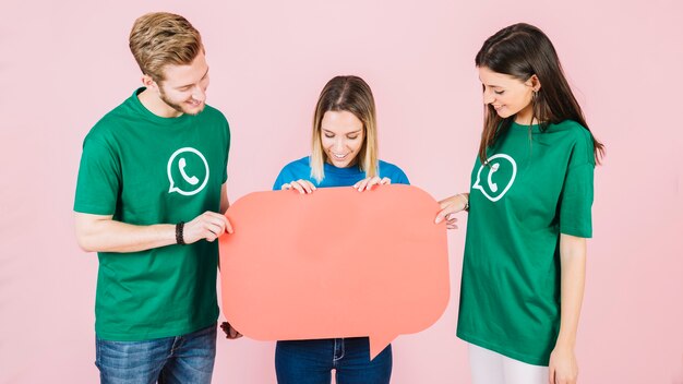 Group of happy friends holding empty orange speech bubble