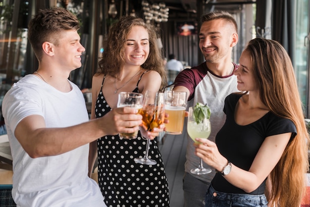 Group of happy friends holding set of drinks