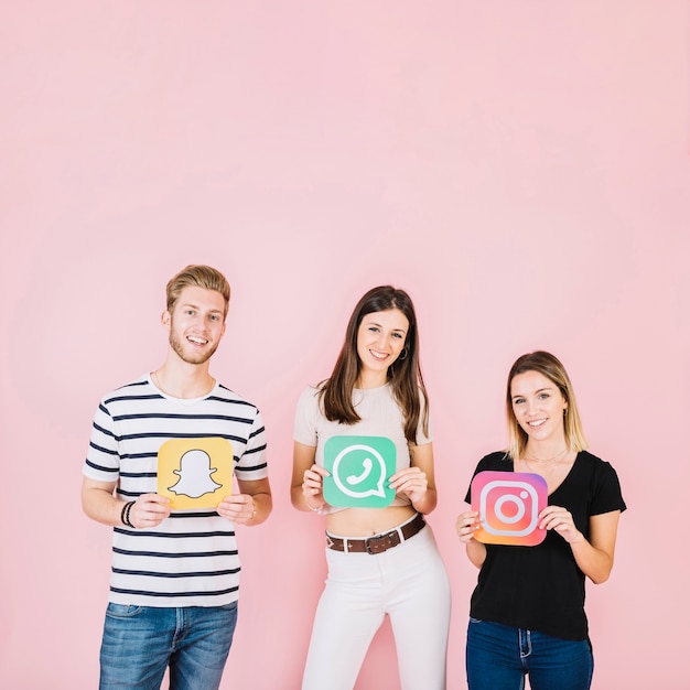 Group of happy friends holding various social media icons