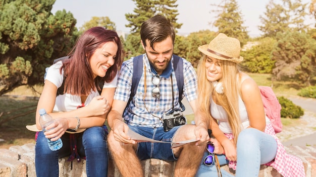 Group of happy friends looking at map