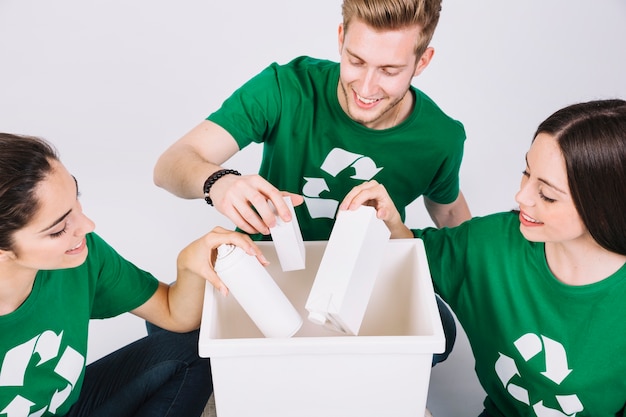 Free photo group of happy friends throwing bottles in white dustbin