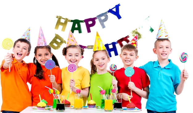 Gruppo di bambini felici con caramelle colorate divertendosi alla festa di compleanno - isolato su un bianco