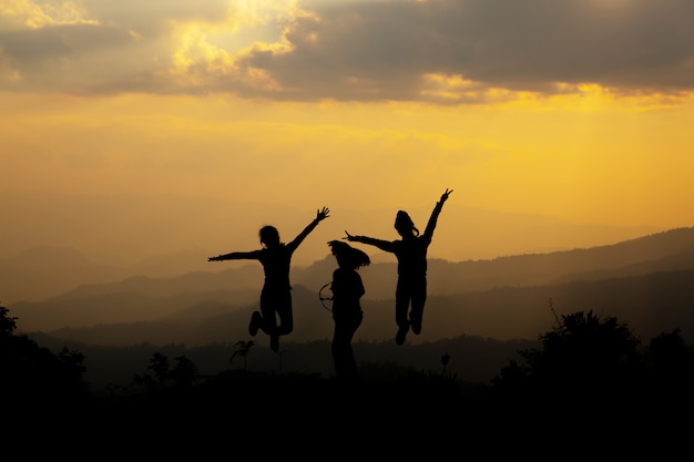 Группа счастливых людей, прыжки в горы на закате
