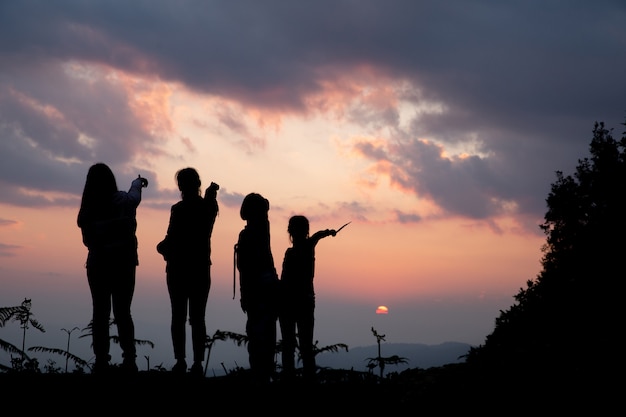 夏の夕暮れ時の自然の中で遊んで幸せな人々のグループ