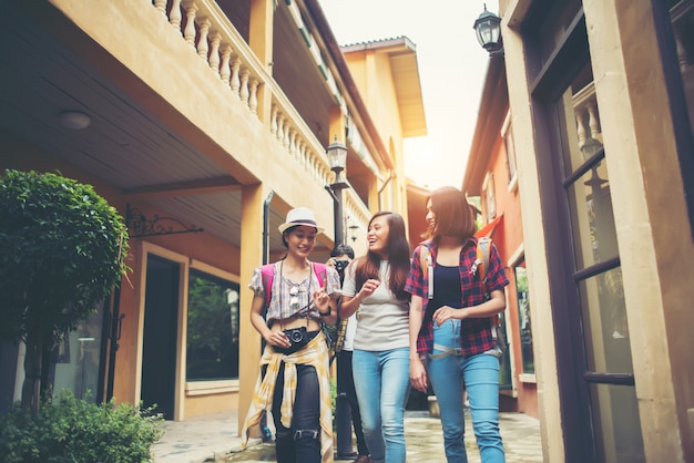 Group of happy young friends having fun walking in urban street. Friendship travel concept.