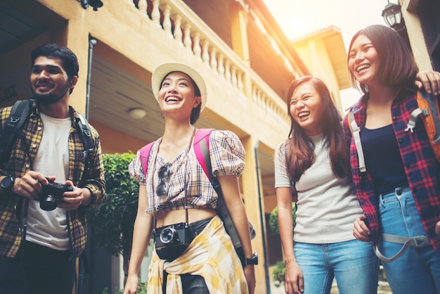 Group of happy young friends having fun walking in urban street. Friendship travel concept.