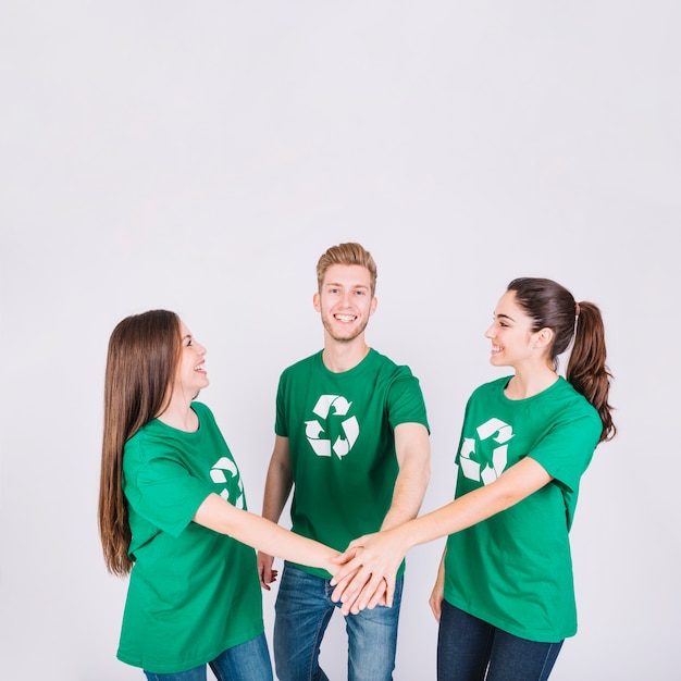 Group of happy young friends stacking their hands