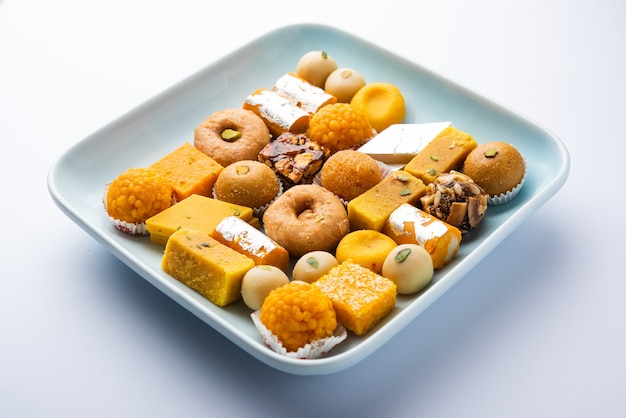 Group of indian assorted sweets or mithai with diya