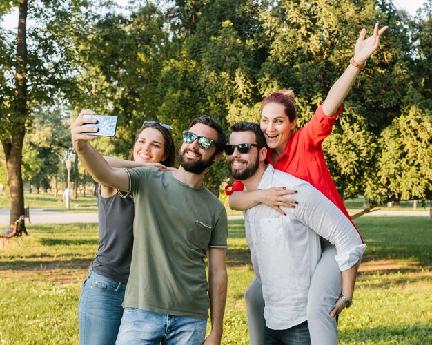 Group of joyful adult friends taking selfie together