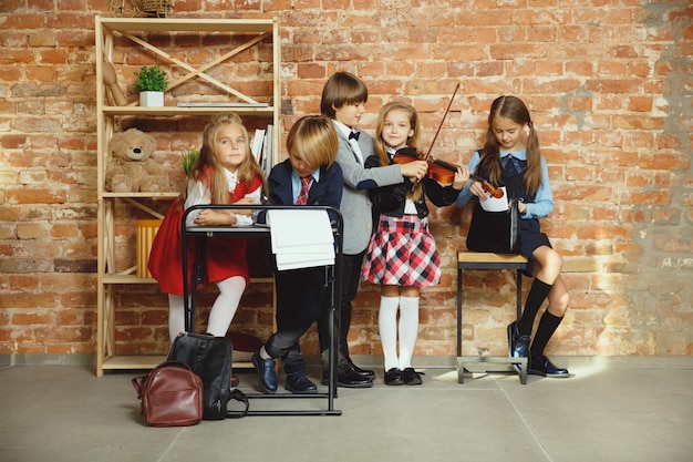 Foto gratuita gruppo di bambini che trascorrono del tempo insieme dopo la scuola. amici belli che riposano dopo le lezioni prima di iniziare a fare i compiti