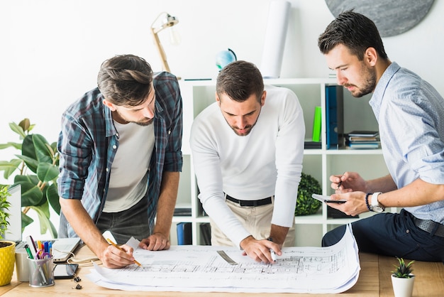 Group of male architect analyzing blueprint