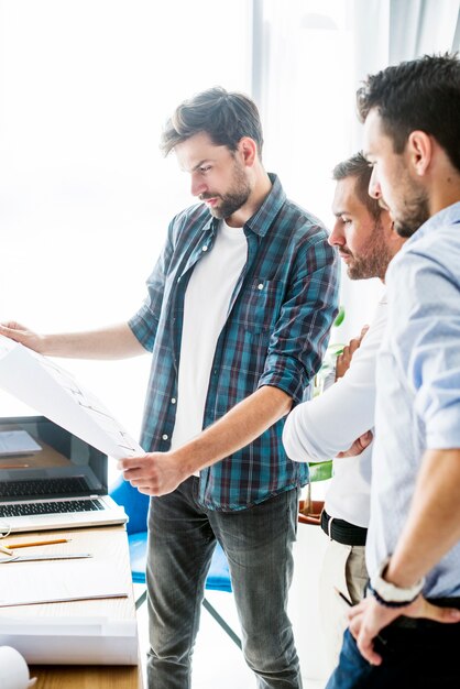 Group of male architect looking at blueprint