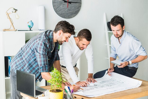Group of male architect preparing blueprint in office