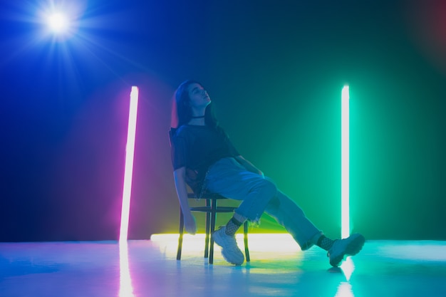 Group of male and female dancers in colorful neon light having fun dancing.