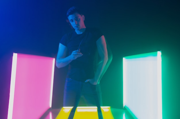 Group of male and female dancers in colorful neon light having fun dancing.