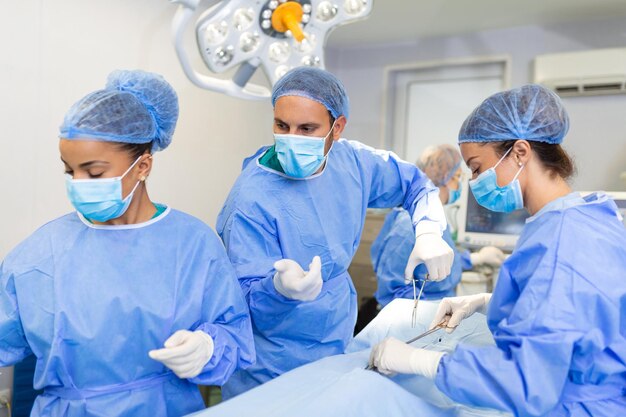병원에서 긴급히 외과 수술을 하고 환자를 돕는 의료진 그룹 밝고 현대적인 수술실에서 수술을 하는 의료 팀