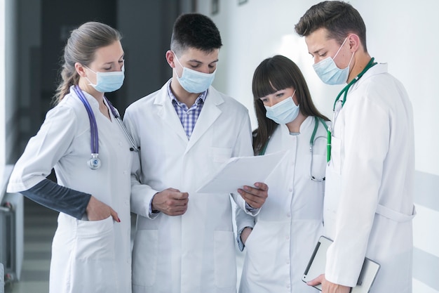 Free photo group of medics in masks reading paper