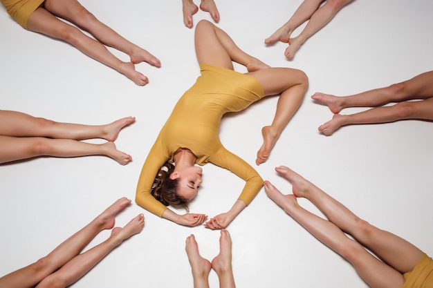 Free photo group of modern ballet dancers lying on the floor