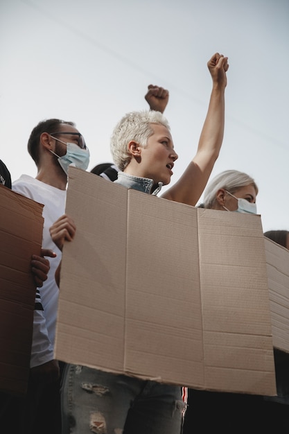 Бесплатное фото Группа активистов выступает с лозунгами на митинге. мужчины и женщины маршируют вместе в знак протеста