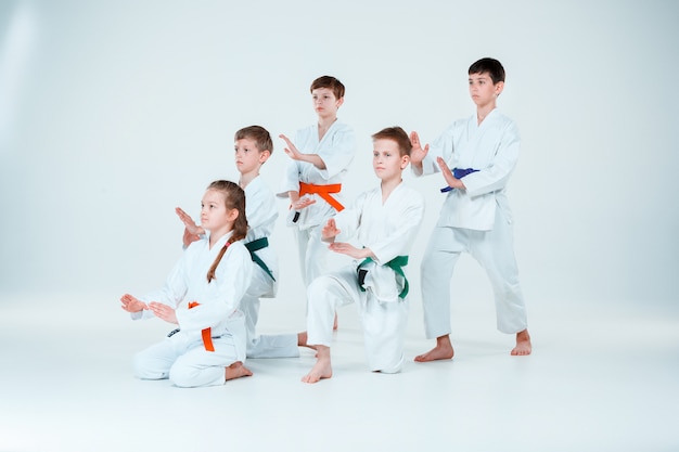 Бесплатное фото Группа юношей и девушек воюет в айкидо на тренировке в школе боевых искусств. концепция здорового образа жизни и спорта
