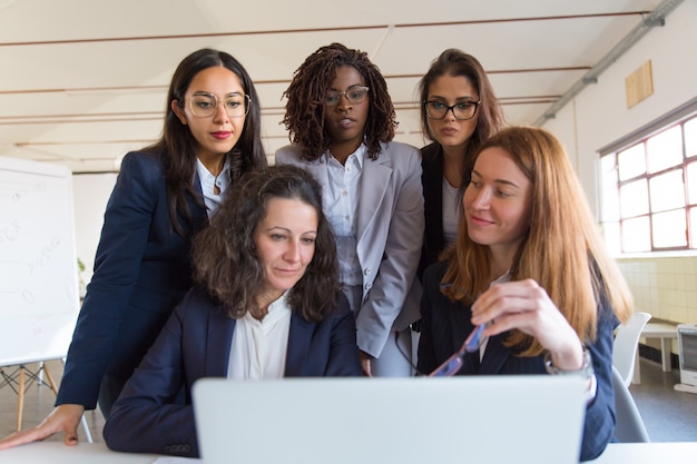 Бесплатное фото Группа деловых женщин, работающих с ноутбуком