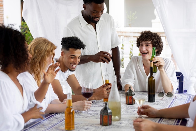 Бесплатное фото Группа друзей веселится во время белой вечеринки с напитками