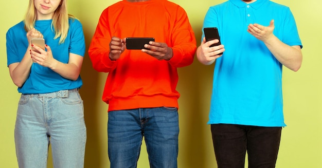 モバイルスマートフォンを使用している友人のグループティーンエイジャーの新しいテクノロジーのトレンドへの依存症がクローズアップ
