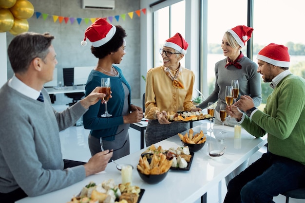 사무실에서 크리스마스 파티에 대해 이야기하는 행복한 비즈니스 동료 그룹
