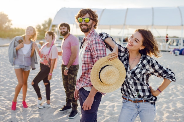 Бесплатное фото Группа счастливых друзей, проводящих удивительное время вместе и гуляющих по солнечному берегу