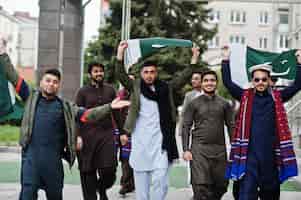 Бесплатное фото Группа пакистанских мужчин в традиционной одежде сальвар камиз или курта с пакистанскими флагами