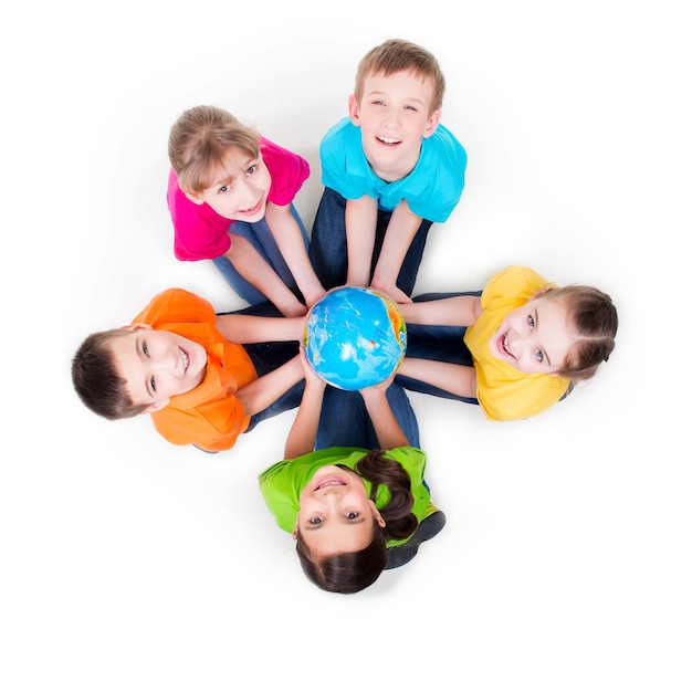 無料写真 地球儀を手に円を描くように床に座っている笑顔の子供たちのグループ-白で隔離。