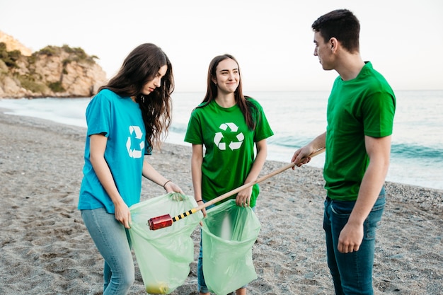 Бесплатное фото Группа добровольцев, собирающих отходы на пляже