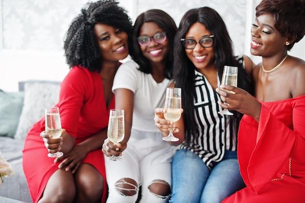 Group of partying african girls clinking glasses with sparkling wine champagne