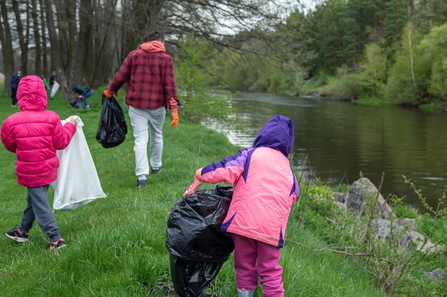 A group of people clean up the trash at the exit to the forest, in the spring
