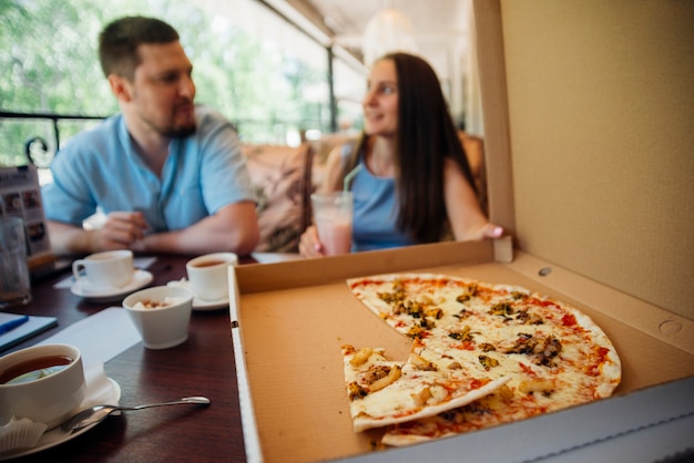 Group of people eating pizza in cafe