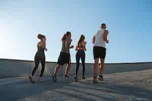 Free photo group of people exercising together outdoors