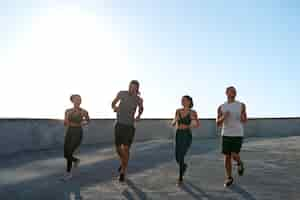 Free photo group of people exercising together outdoors