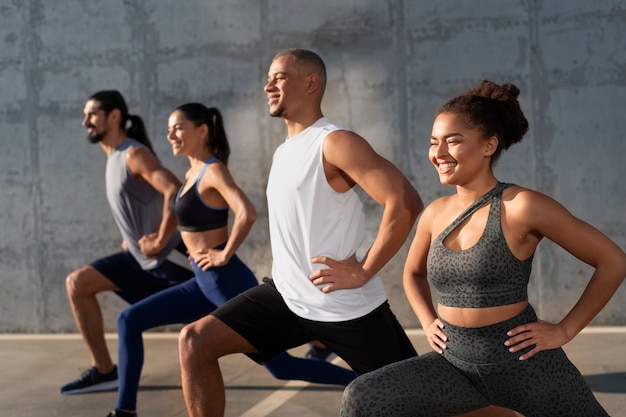 Free photo group of people exercising together outdoors