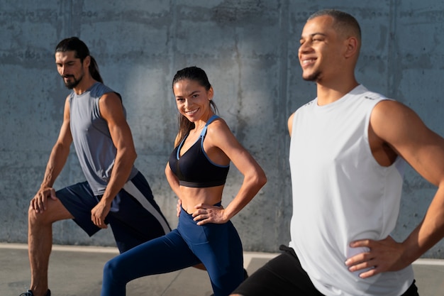 Free photo group of people exercising together outdoors