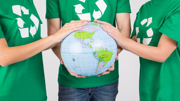 Group of people holding globe in hands together