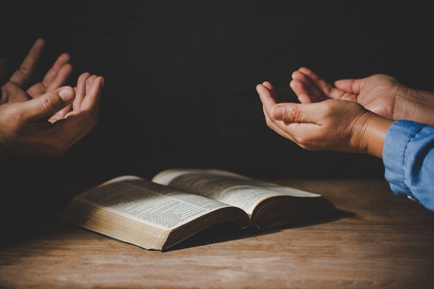 group of people holding hands praying worship believe