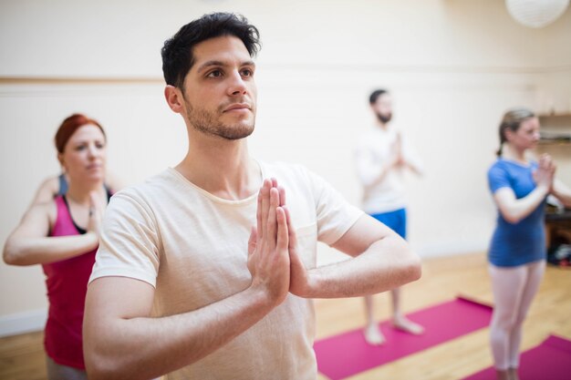 Group of people performing tree-pose yoga exercise