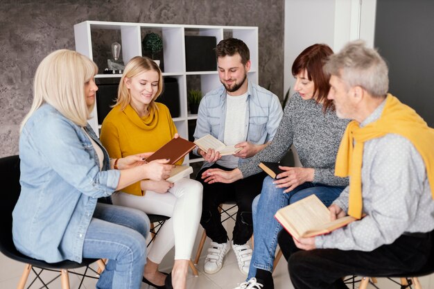 group of people reading books at therapy session