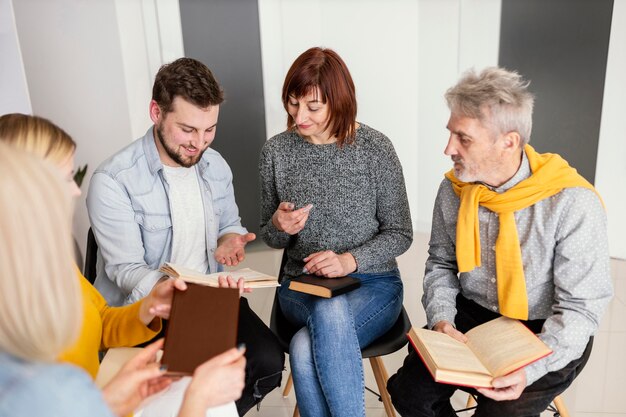 group of people reading books at therapy session