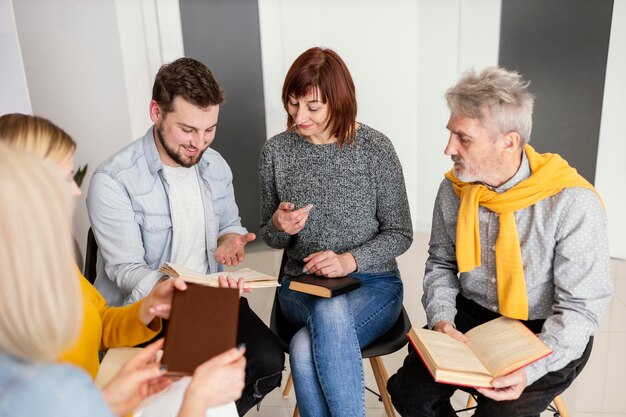 Group of people reading books at therapy session