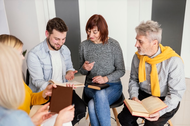 Group of people reading books at therapy session