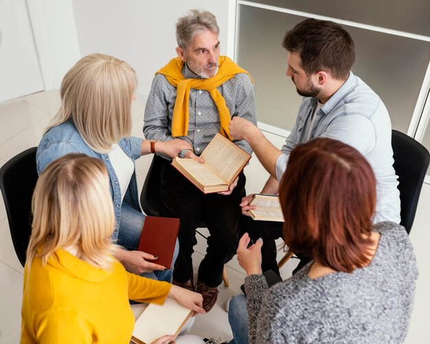 Group of people reading books at therapy session