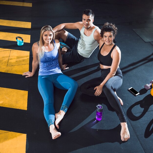 Group of people sitting on floor in fitness club