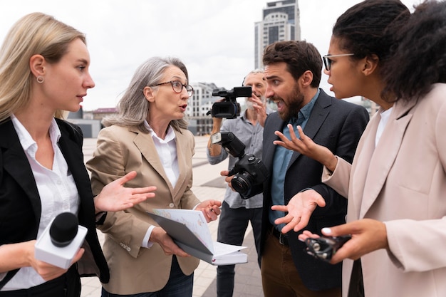 Free photo group of people taking an interview outdoors